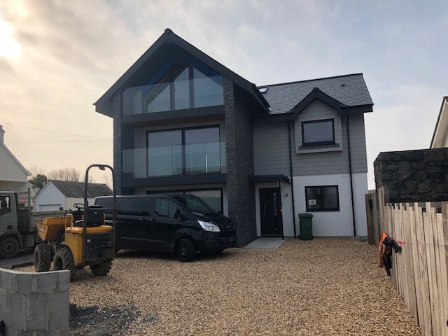 Norstone Charcoal Slimline Stone Veneer Panels used on an exterior feature wall on a residential home with grey stucco, siding and dark colored trim and windows